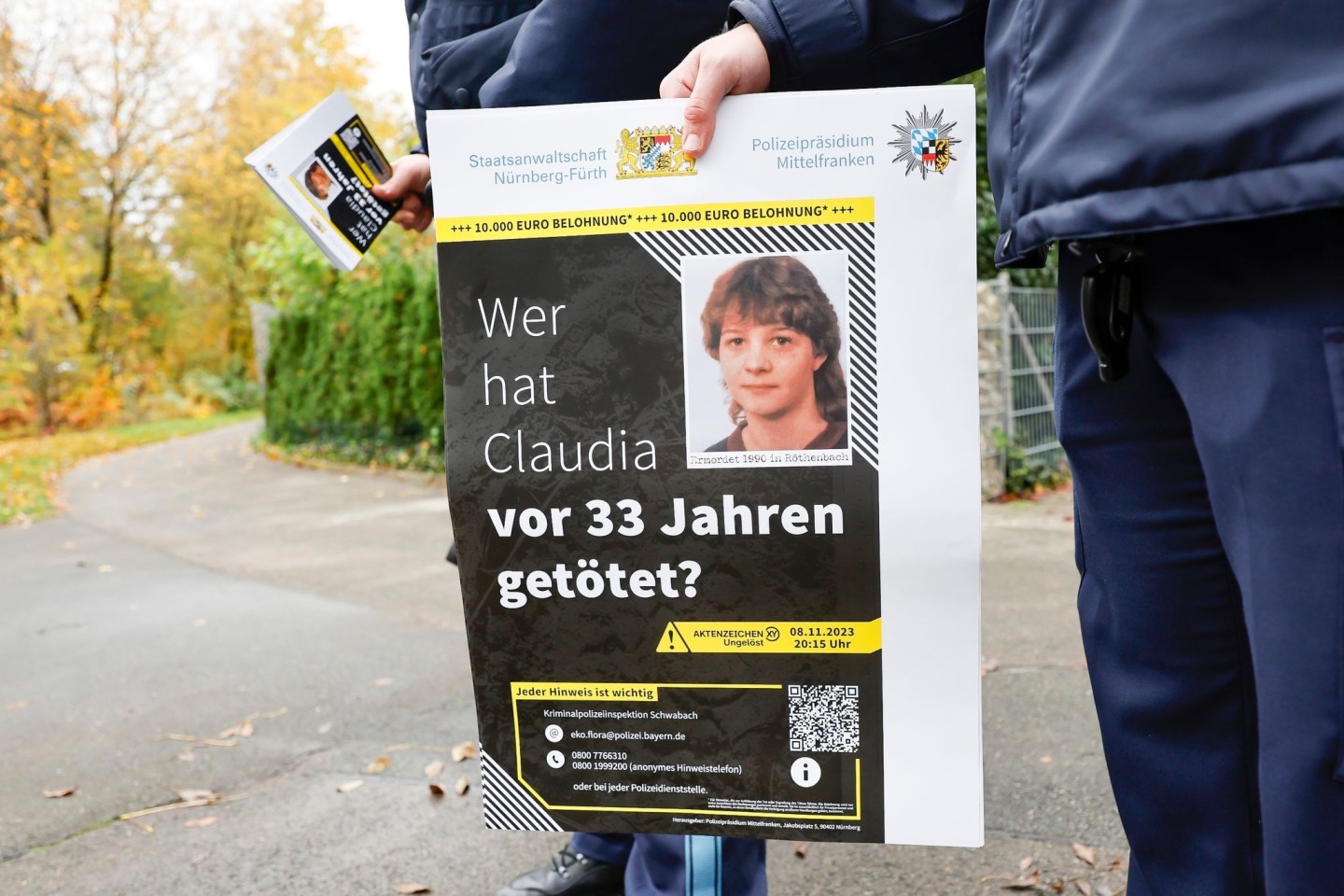 Ein Polizist mit einem Plakat zum Mordfall von 1990 in Röthenbach an der Pegnitz.